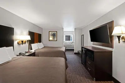 a hotel room with two beds and a flat screen tv at Best Western Executive Inn in Grove City