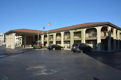 a large building with two cars parked in a parking lot at Best Western Executive Inn in Grove City
