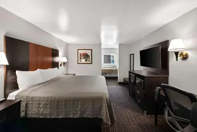 a hotel room with a bed and a flat screen tv at Best Western Executive Inn in Grove City