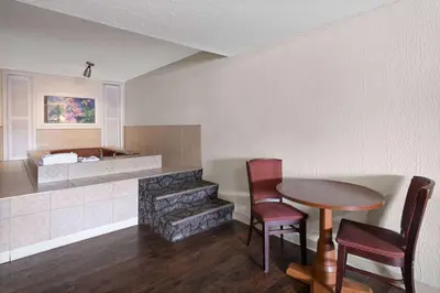 a living room with a table and chairs and a fireplace at Super 8 by Wyndham Youngstown Girard in Youngstown