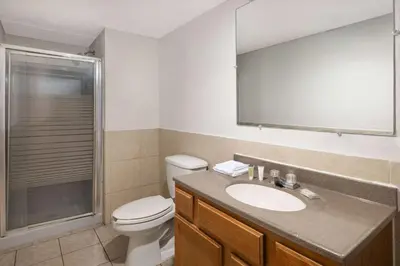 a bathroom with a toilet and a sink and a shower at Super 8 by Wyndham Youngstown Girard in Youngstown