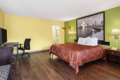 a hotel room with a large bed and a desk at Super 8 by Wyndham Youngstown Girard in Youngstown