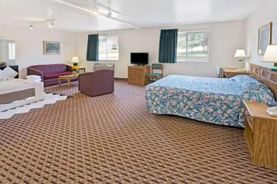 a hotel room with a bed and a living room at Super 8 by Wyndham Canonsburg/Pittsburgh Area in Canonsburg