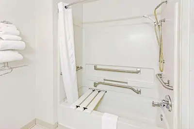 a bathroom with a tub and a shower with towels at Super 8 by Wyndham Canonsburg/Pittsburgh Area in Canonsburg