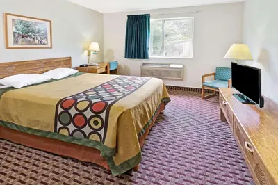 a hotel room with a bed and a flat screen tv at Super 8 by Wyndham Canonsburg/Pittsburgh Area in Canonsburg