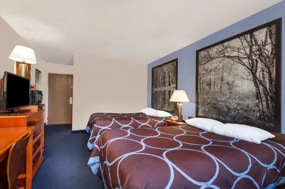 a hotel room with a bed and a flat screen tv at Super 8 by Wyndham Adrian in Adrian