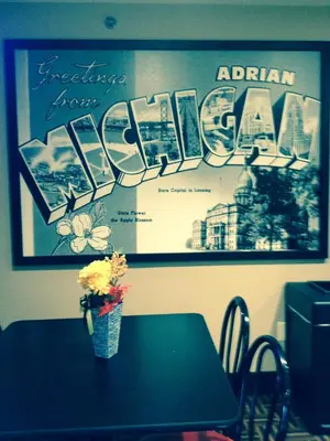 a table with a vase of flowers on top of it at Super 8 by Wyndham Adrian in Adrian