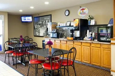 a restaurant with tables and chairs and a counter at Super 8 by Wyndham Adrian in Adrian