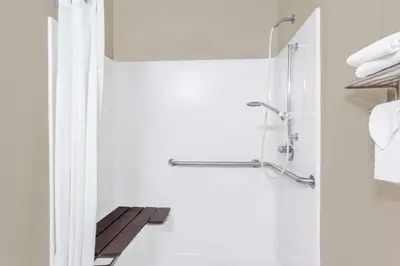 a bathroom with a shower with a glass door at Super 8 by Wyndham Adrian in Adrian