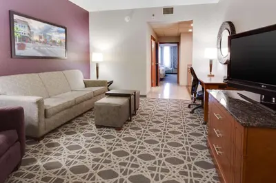 a living room with a couch and a flat screen tv at Drury Inn & Suites Middletown Franklin in Middletown