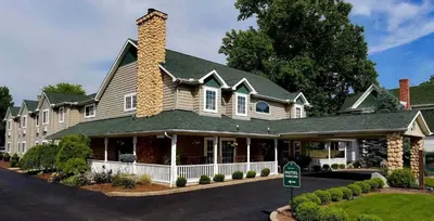 a large house with a chimney on a street at Hearthstone Inn & Suites in Cedarville