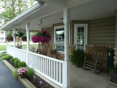 a porch with chairs and flowers on a house at Hearthstone Inn & Suites in Cedarville