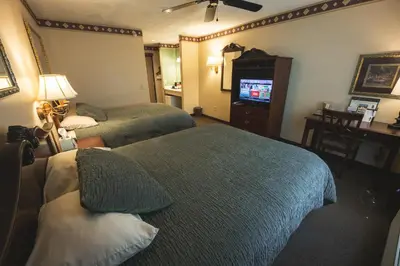 a hotel room with two beds and a television at Hearthstone Inn & Suites in Cedarville