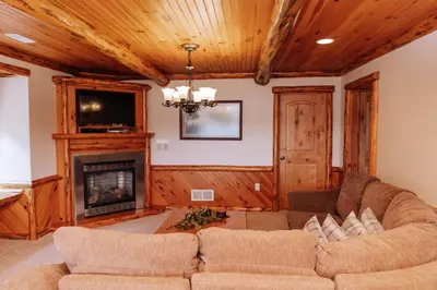 a living room with a couch and a fireplace at Sojourner's Lodge & Log Cabin Suites in Dundee