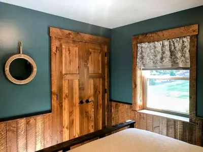 a bedroom with a wooden door and a window at Sojourner's Lodge & Log Cabin Suites in Dundee