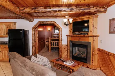 a living room with a couch and a fireplace at Sojourner's Lodge & Log Cabin Suites in Dundee