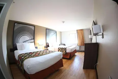 a hotel room with two beds and a television at Super 8 by Wyndham Portsmouth in Portsmouth