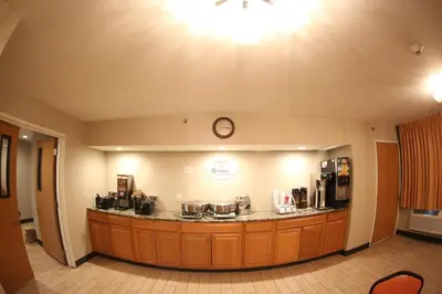 a waiting area of a coffee shop with a clock on the wall at Super 8 by Wyndham Portsmouth in Portsmouth