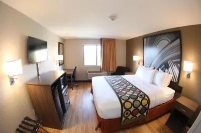 a hotel room with a large bed and a desk at Super 8 by Wyndham Portsmouth in Portsmouth