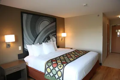a hotel room with a large bed in a room at Super 8 by Wyndham Portsmouth in Portsmouth
