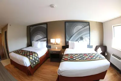 a hotel room with two beds and two lamps at Super 8 by Wyndham Portsmouth in Portsmouth