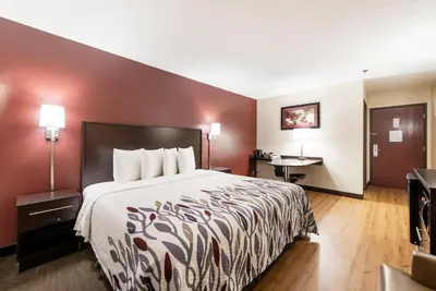 a hotel room with a bed and a desk at Red Roof Inn Auburn in Auburn
