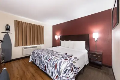 a hotel room with a large bed and a window at Red Roof Inn Auburn in Auburn
