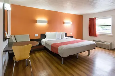a hotel room with a bed and a desk and a table at Motel 6-Sidney, OH in Sidney