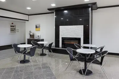 a room with tables and chairs and a fireplace at Motel 6-Sidney, OH in Sidney
