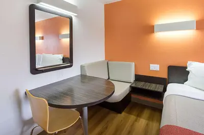 a room with a table and a bed and a mirror at Motel 6-Sidney, OH in Sidney
