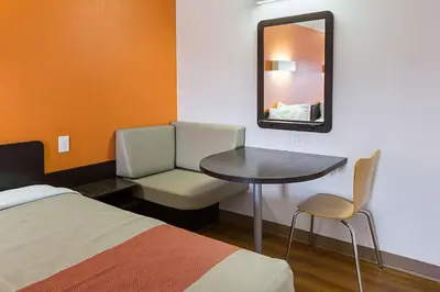 a room with a bed and a table and a mirror at Motel 6-Sidney, OH in Sidney