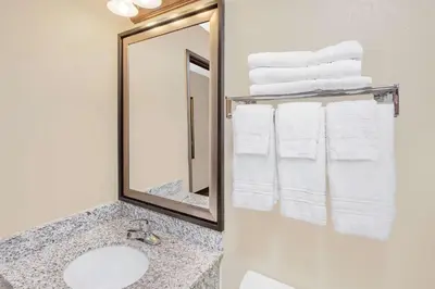 a bathroom with a sink and a mirror and towels at Super 8 by Wyndham Seville in Seville