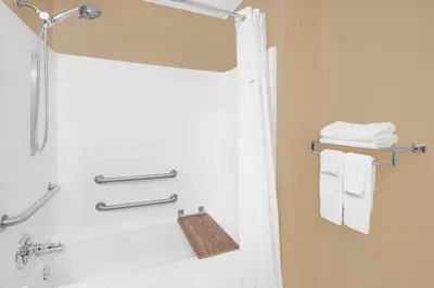 a bathroom with a shower with a shower curtain and towels at Super 8 by Wyndham Seville in Seville
