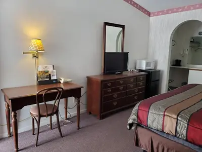 a hotel room with a desk and a bed and a bed and a desk with at Bryan Inn in Bryan