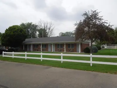 a white fence in front of a house at Bryan Inn in Bryan