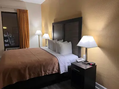 a hotel room with a bed with two lamps and a phone at Quality Inn Maysville in Maysville