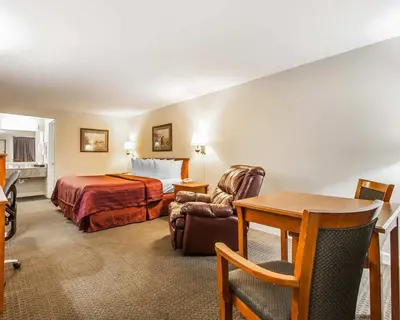 a hotel room with a bed and a table at Quality Inn Maysville in Maysville