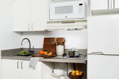 a white kitchen with a sink and a microwave at InTown Suites Extended Stay Columbus OH - I-70E Hamilton Rd in Columbus