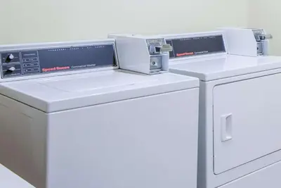 two white washing machines sitting next to each other at Super 8 by Wyndham Wheeling WV in Wheeling