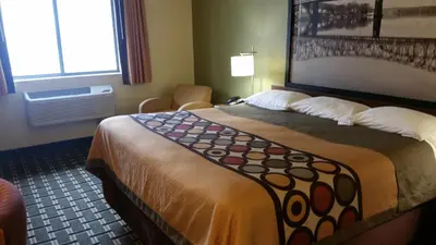 a hotel room with a large bed and a window at Super 8 by Wyndham Wheeling WV in Wheeling