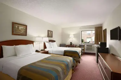 a hotel room with two beds and a television at Days Inn by Wyndham Middletown in Middletown