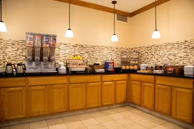a kitchen with wooden cabinets and a counter top at Country Inn & Suites by Radisson, Macedonia, OH in Macedonia