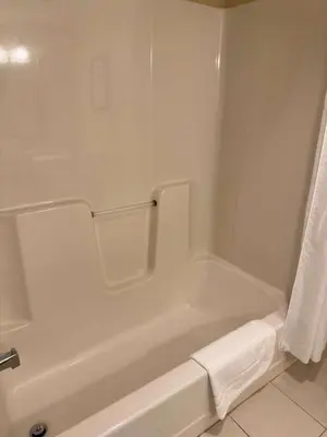 a bathroom with a white bath tub with a towel at Country Inn & Suites by Radisson, Macedonia, OH in Macedonia