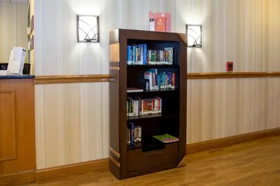 a book shelf filled with books in a room at Country Inn & Suites by Radisson, Macedonia, OH in Macedonia