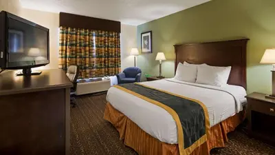 a hotel room with a bed and a flat screen tv at Best Western Richland Inn Mansfield in Mansfield