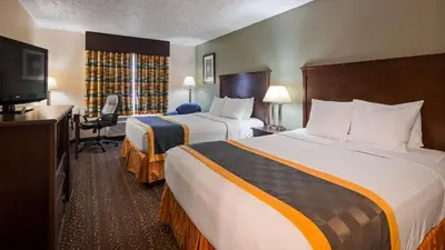 a hotel room with two beds and a flat screen tv at Best Western Richland Inn Mansfield in Mansfield