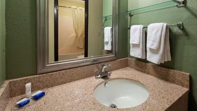 a bathroom with a sink and a mirror and towels at Best Western Richland Inn Mansfield in Mansfield