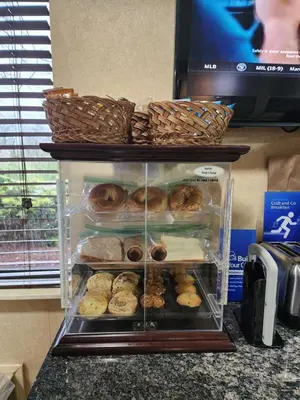a display case filled with donuts on top of a counter at Best Western Richland Inn Mansfield in Mansfield