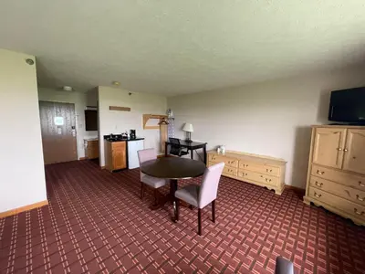 a room with a table and chairs and a kitchen at The Woodridge Inn in Connersville