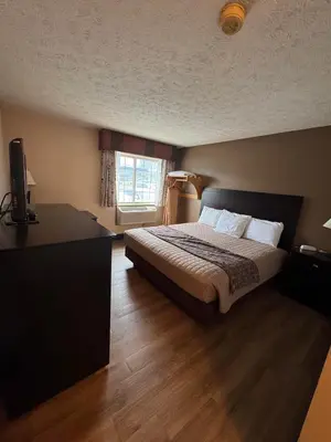 a bedroom with a bed and a desk and a television at The Woodridge Inn in Connersville